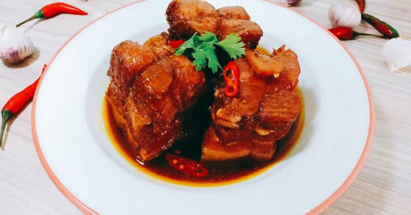 Phần thịt gà rô ti bóng bẩy, màu nâu sẫm hấp dẫn đặt trên đĩa cơm cùng nước sốt sệt.